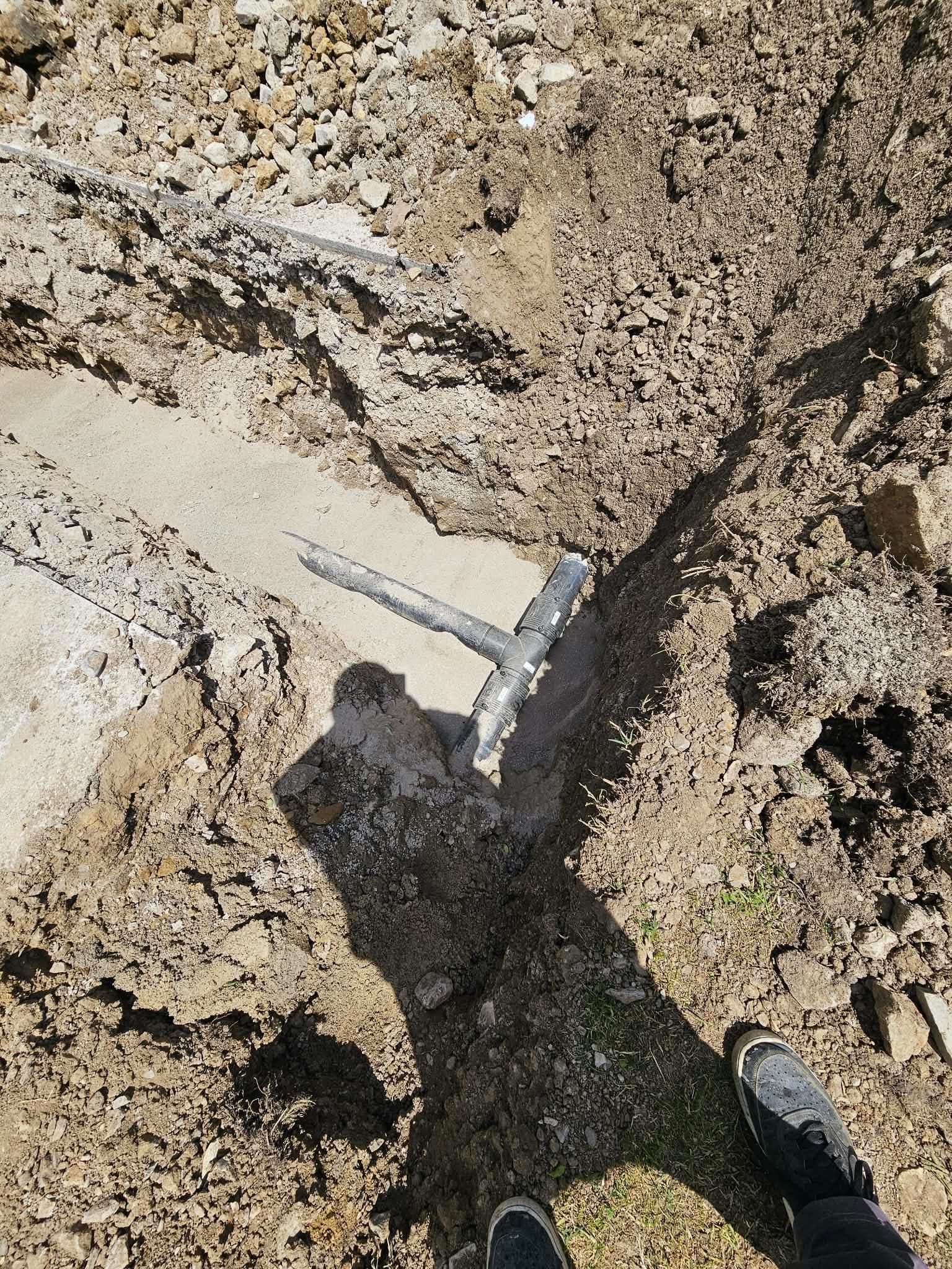 PE тръба с тройник за отклонение, положена върху пясъчна подложка на дъното на изкопа.